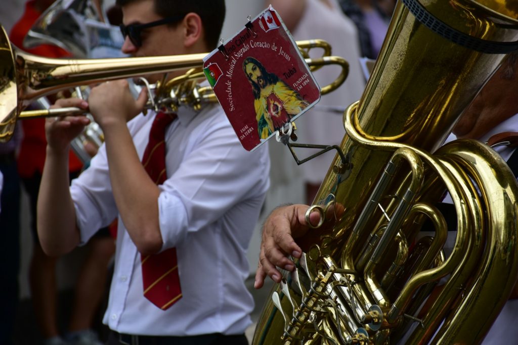 a man in a white shirt and tie playing a trumpet