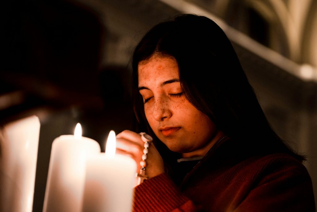 a woman lighting a candle in a church